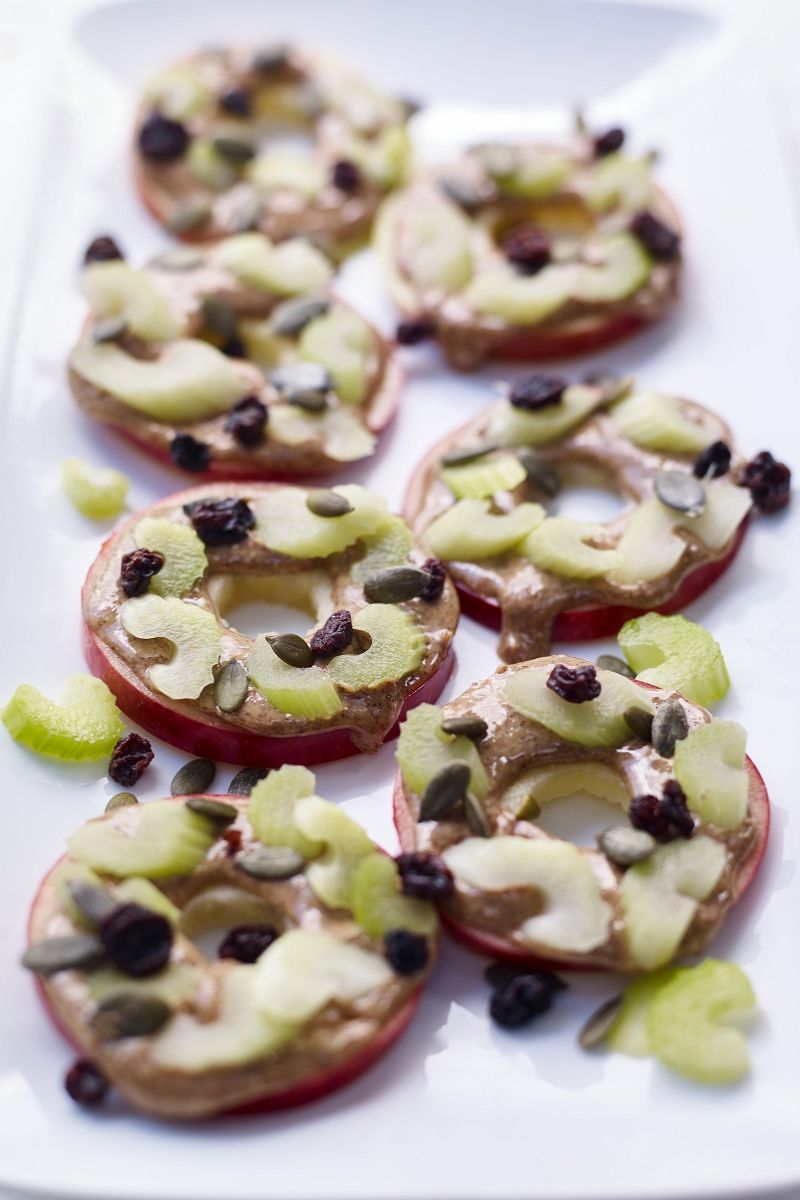 Healthy vegan apple slices with peanut butter, raisins and pumpkin seeds Easy Vegan Apple Snack With Peanut Butter (Healthy 5-Minute Recipe)