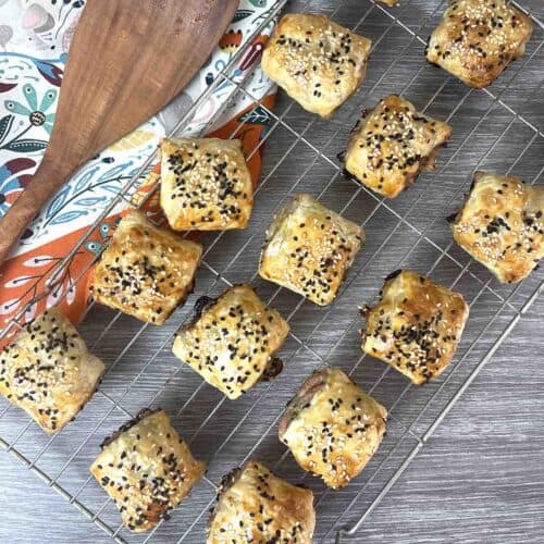 Chicken sausage rolls on a rack.