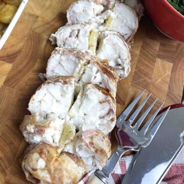 baked monkfish tails sliced on a board.