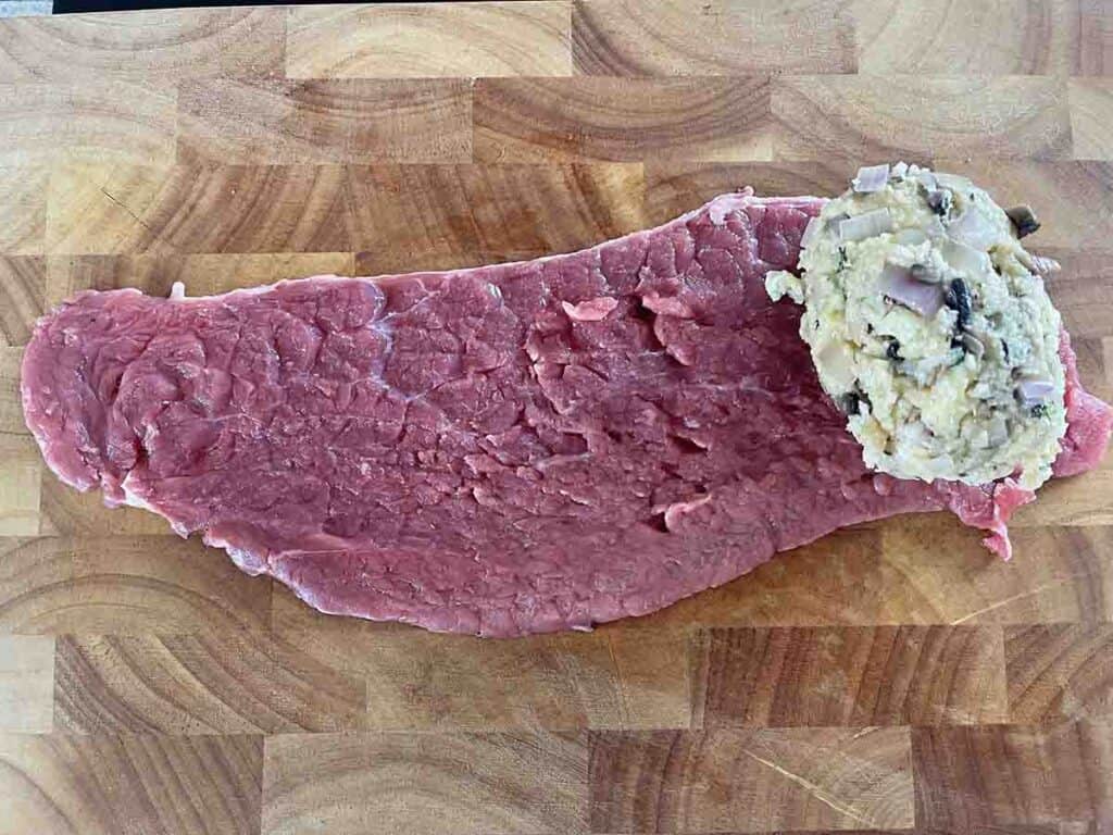 ball of stuffing on the short edge of beef steak.