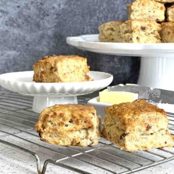 cheese and bacon scones on a rack and some on a stand.