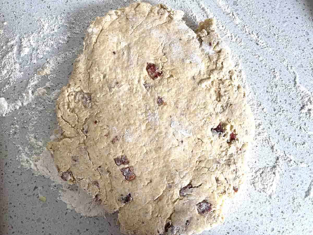 cheese scone mixture rolled out onto a floor board.