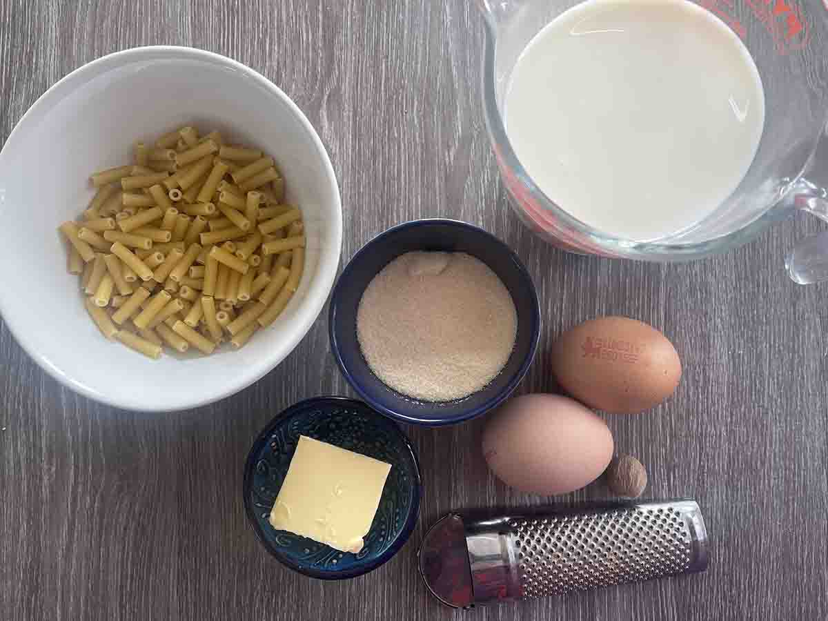 macaroni, sugar, eggs, butter and milk in containers.
