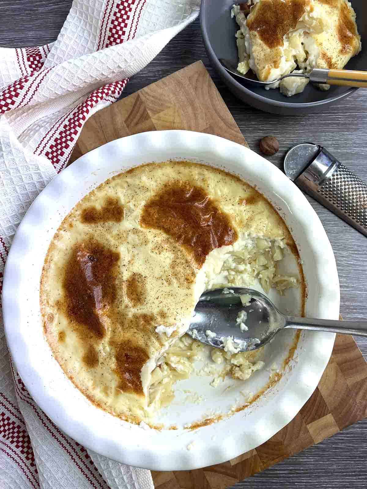 cooked pudding with a portion in a bowl.