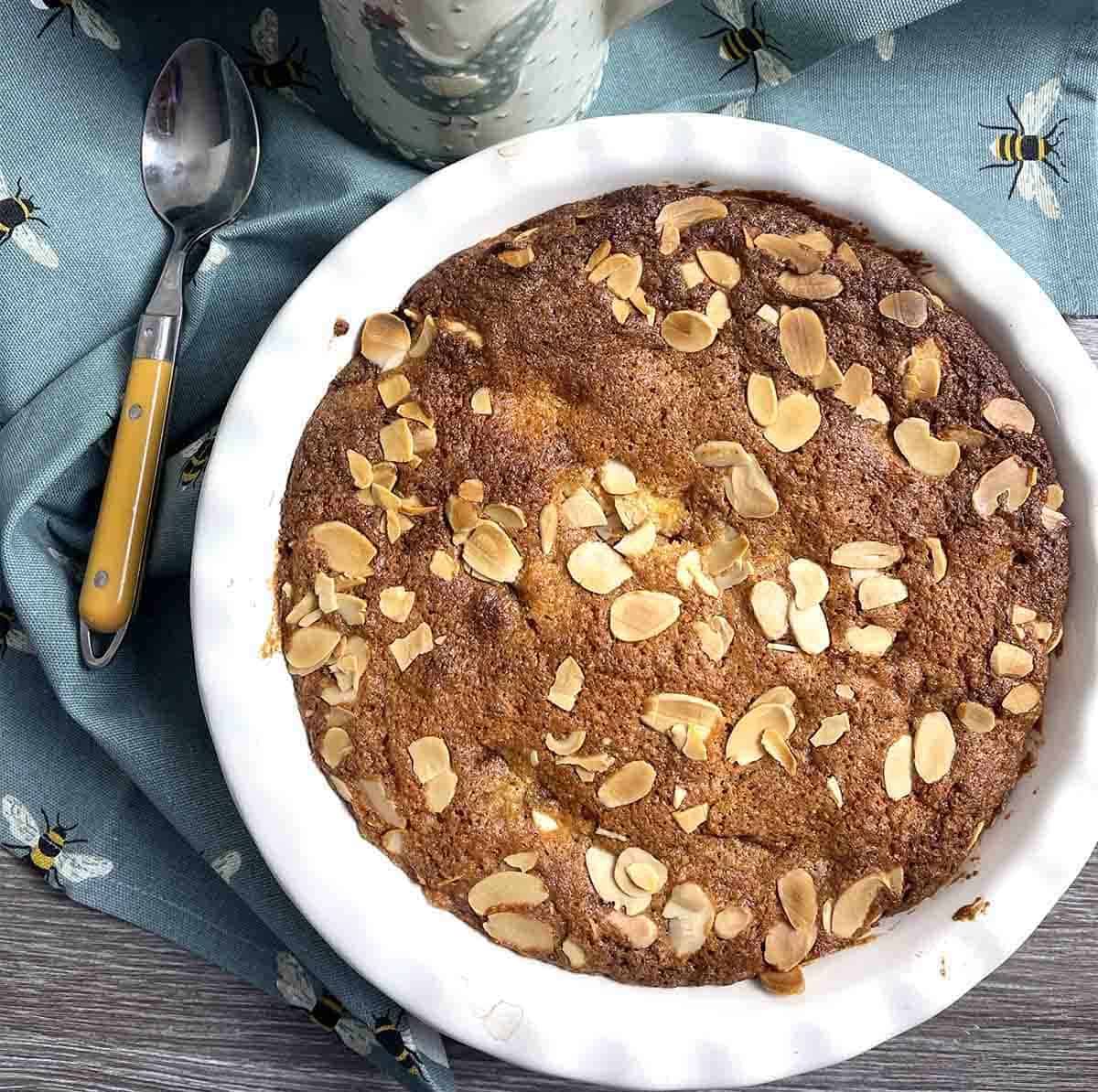 Eve's pudding in a dish with custard in the background.