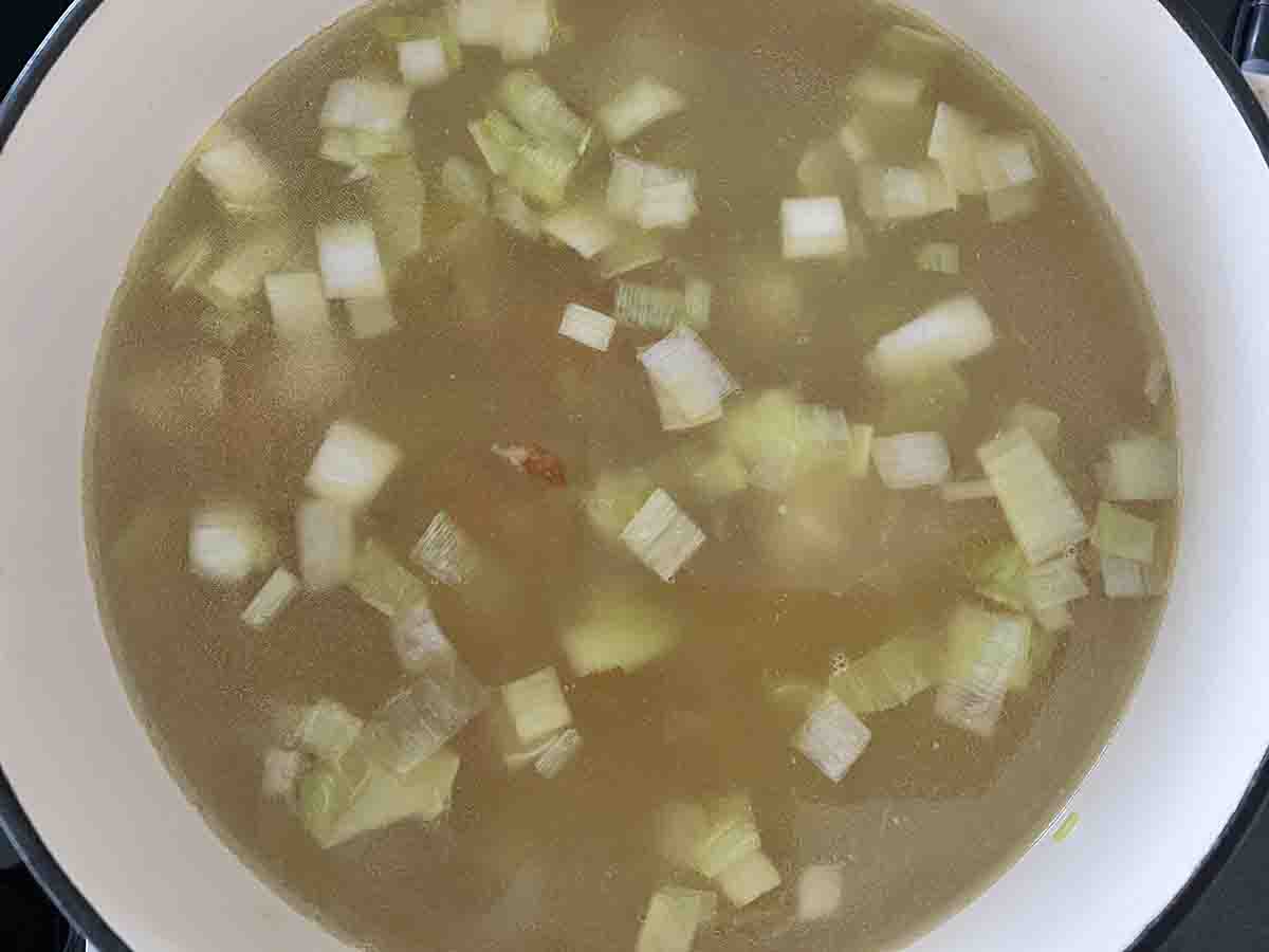 saucepan with stock and peas added.