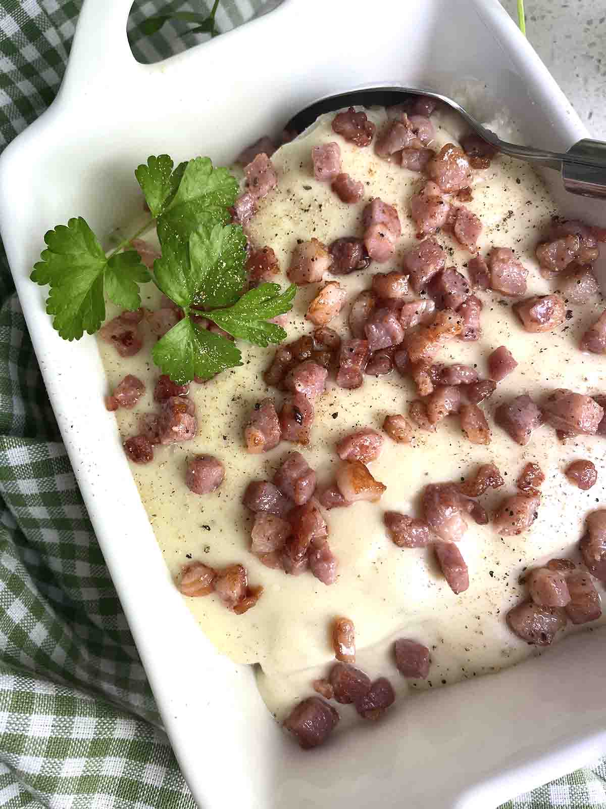leeks in sauce with bacon on top.