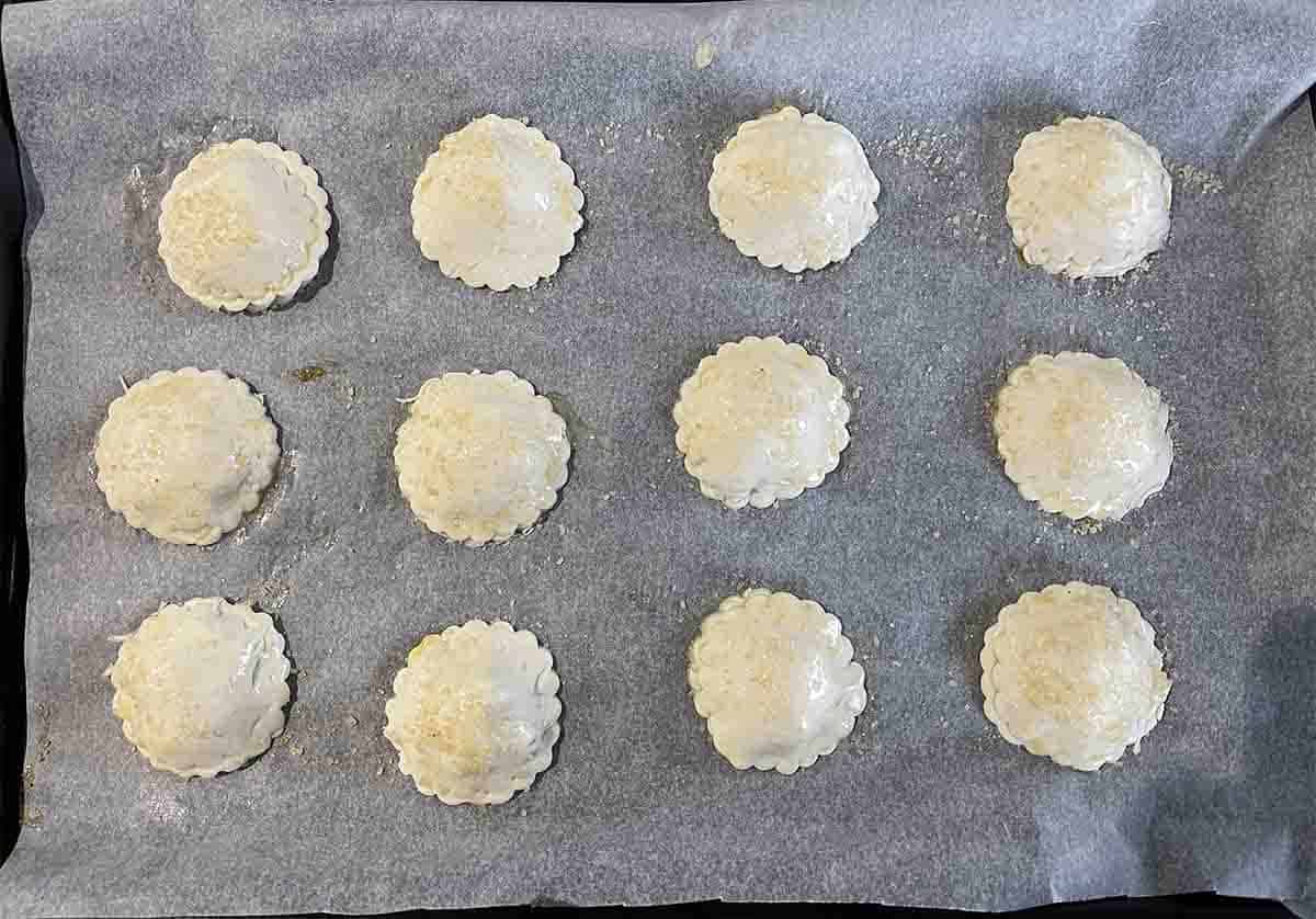pies with egg glaze and sugar on top.