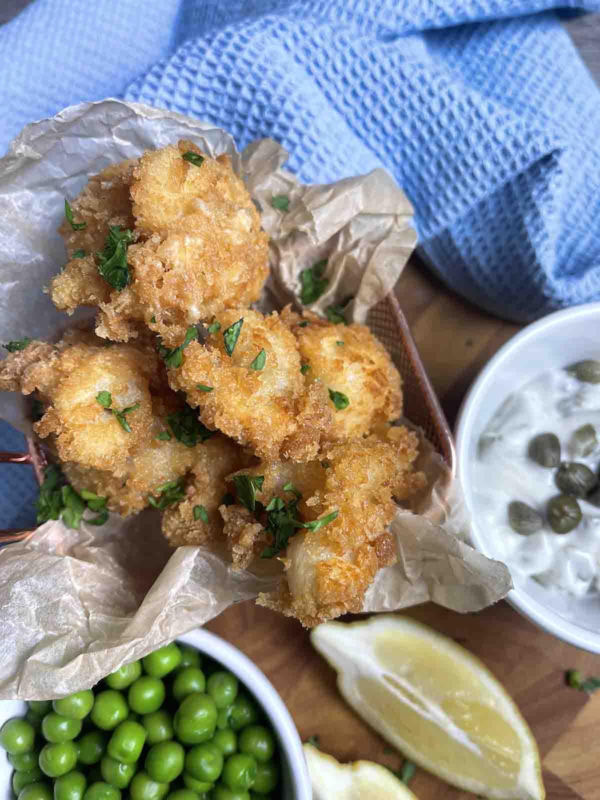 pot of fish in panko and peas in a pot on the left.s