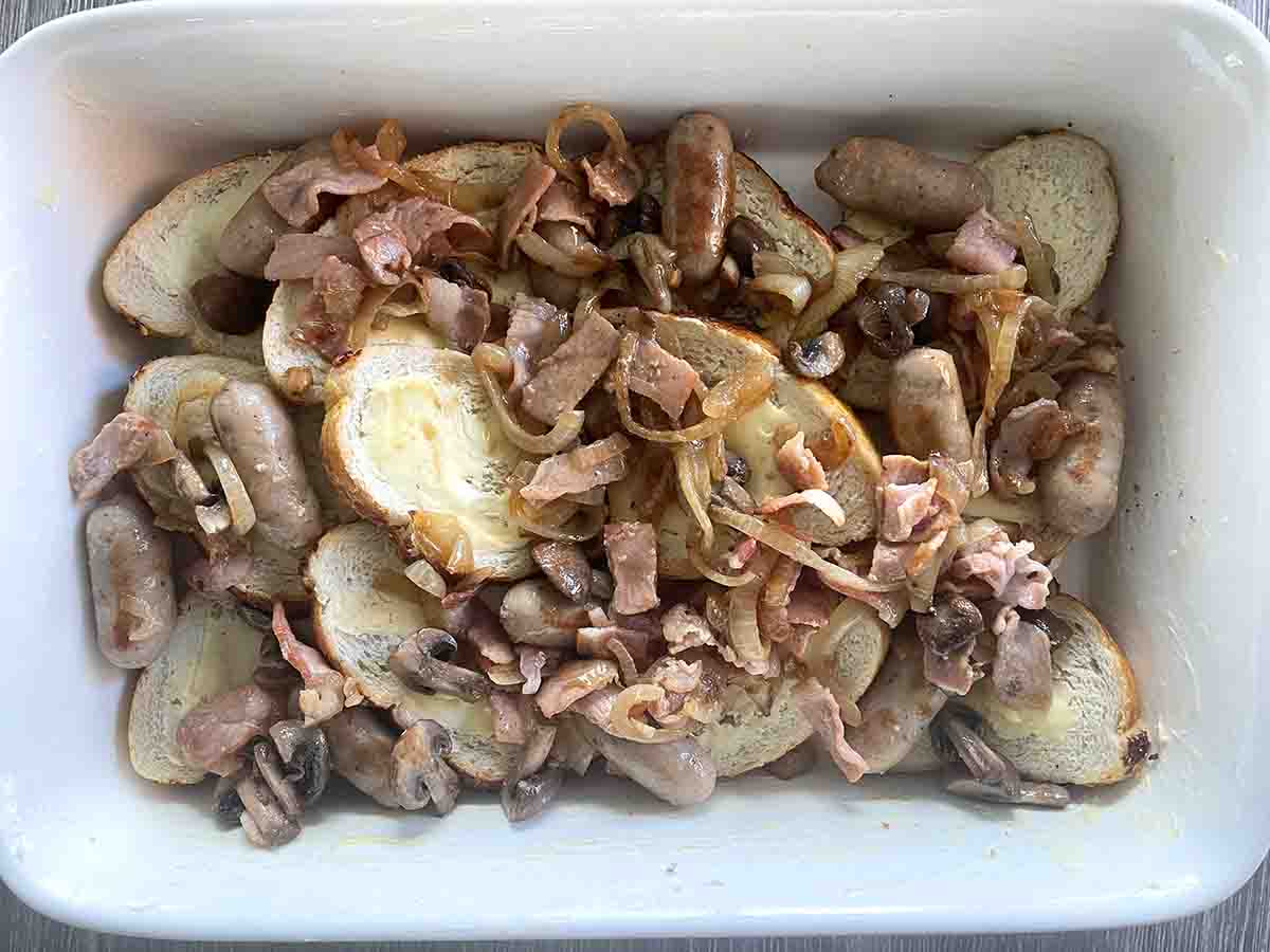 sausage and bacon mix scattered on the bread.