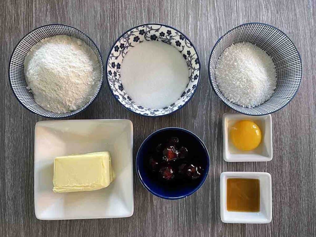ingredients including butter, flour,sugar, egg, cherries, coconut and vanilla essence.