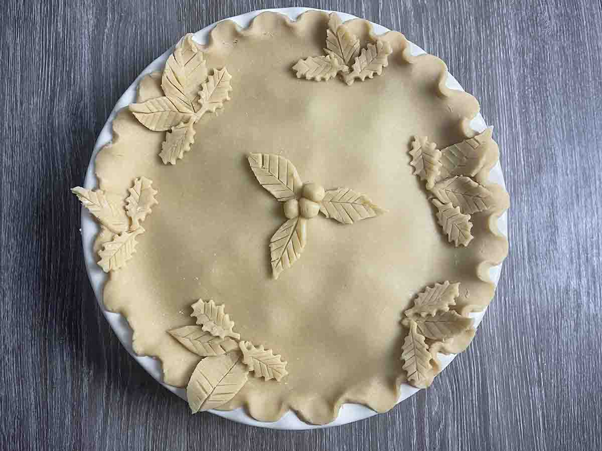 pie decorated with pastry leaves ready for baking.