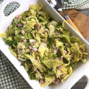fried cabbage with bacon and onions in a serving dish.