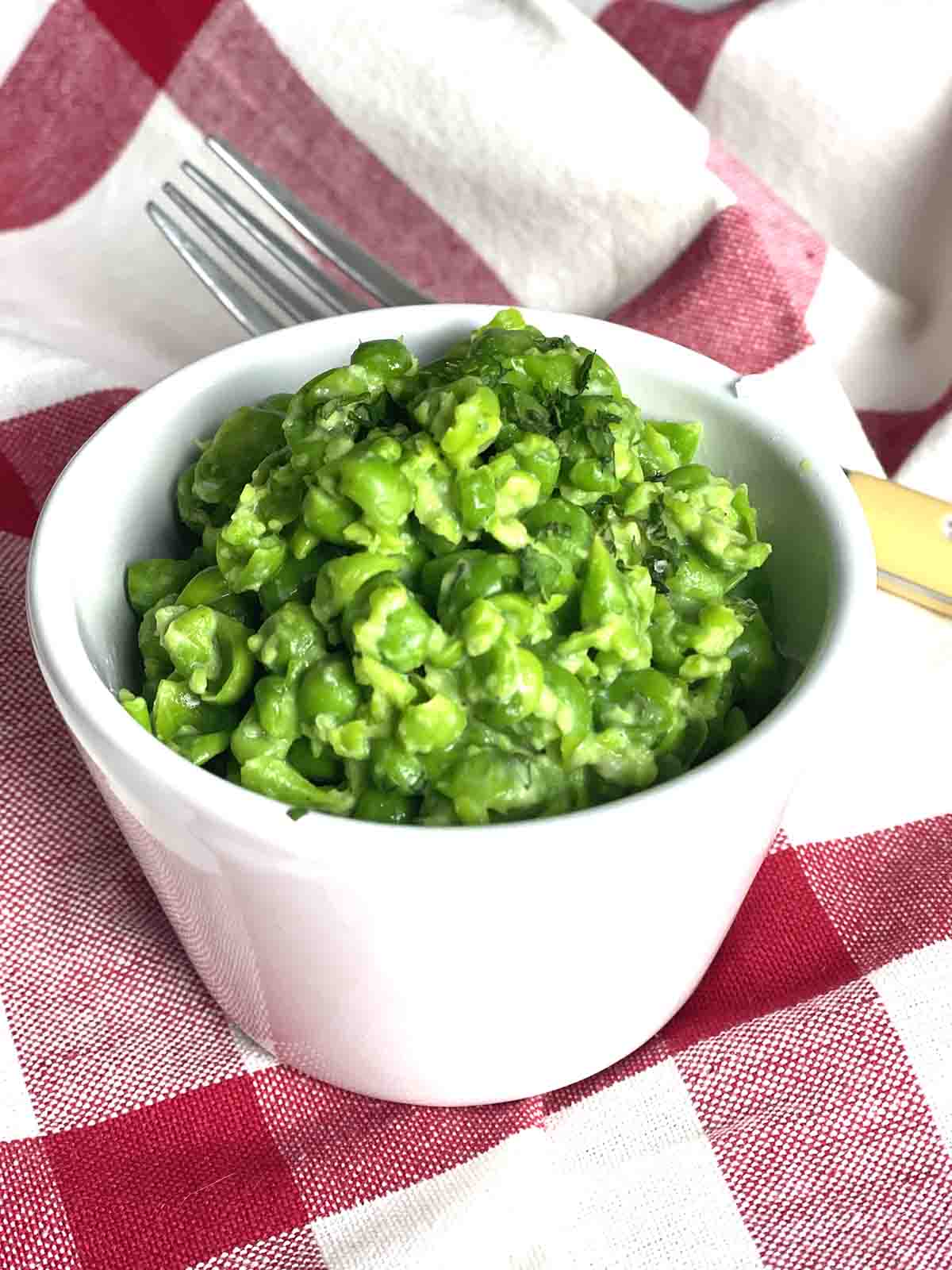 portion of minted mushy peas in a white dish.