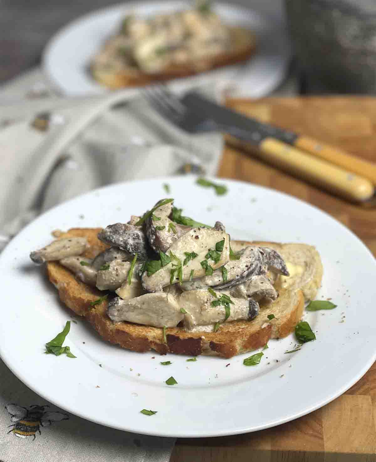 creaed mushrooms ready to eat with a knife and fork.