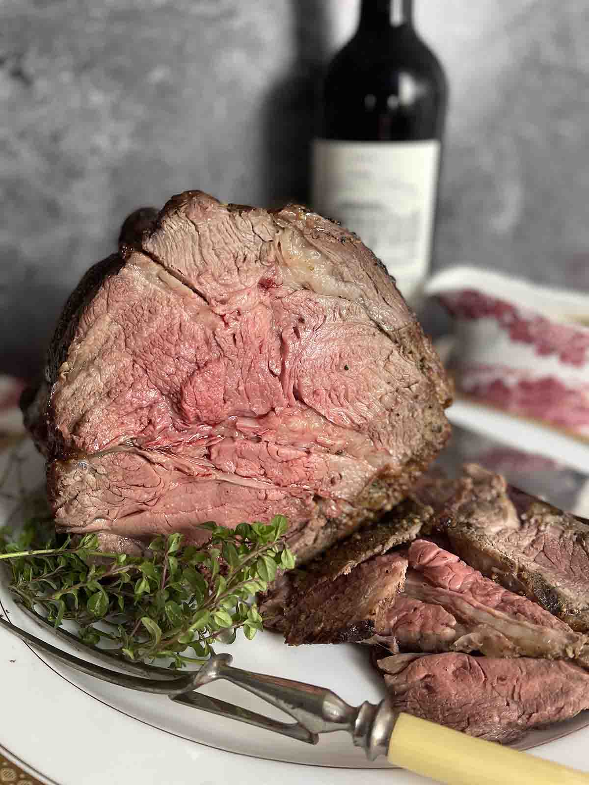 rib of beef on a plate with wine in the background.