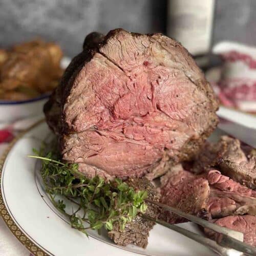 roast rib of beef with slices cut off on a plate.