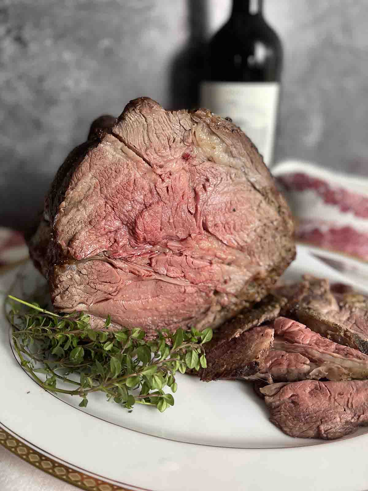 rib of beef on a plate with wine in the background.