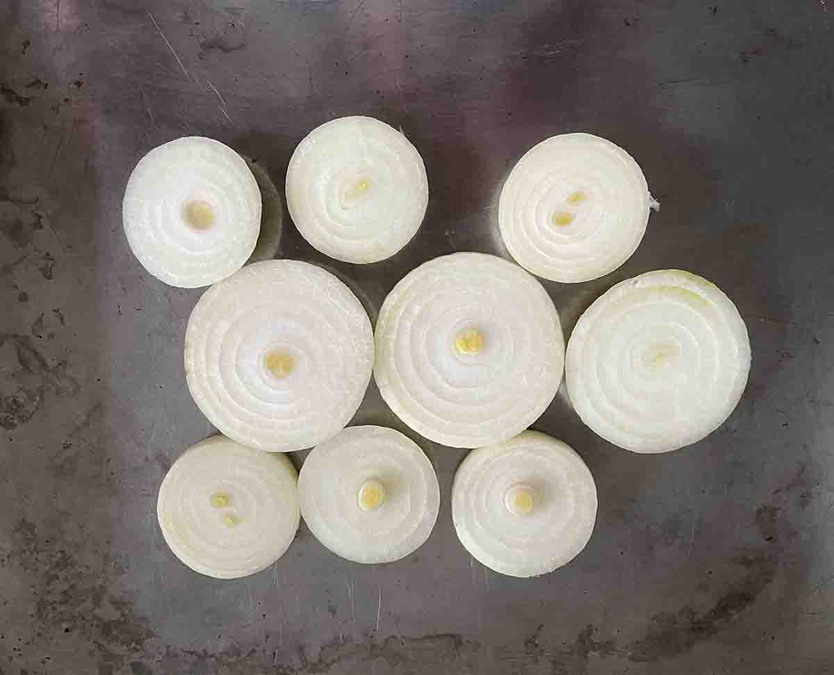 thick sliced onions in a roasting dish.