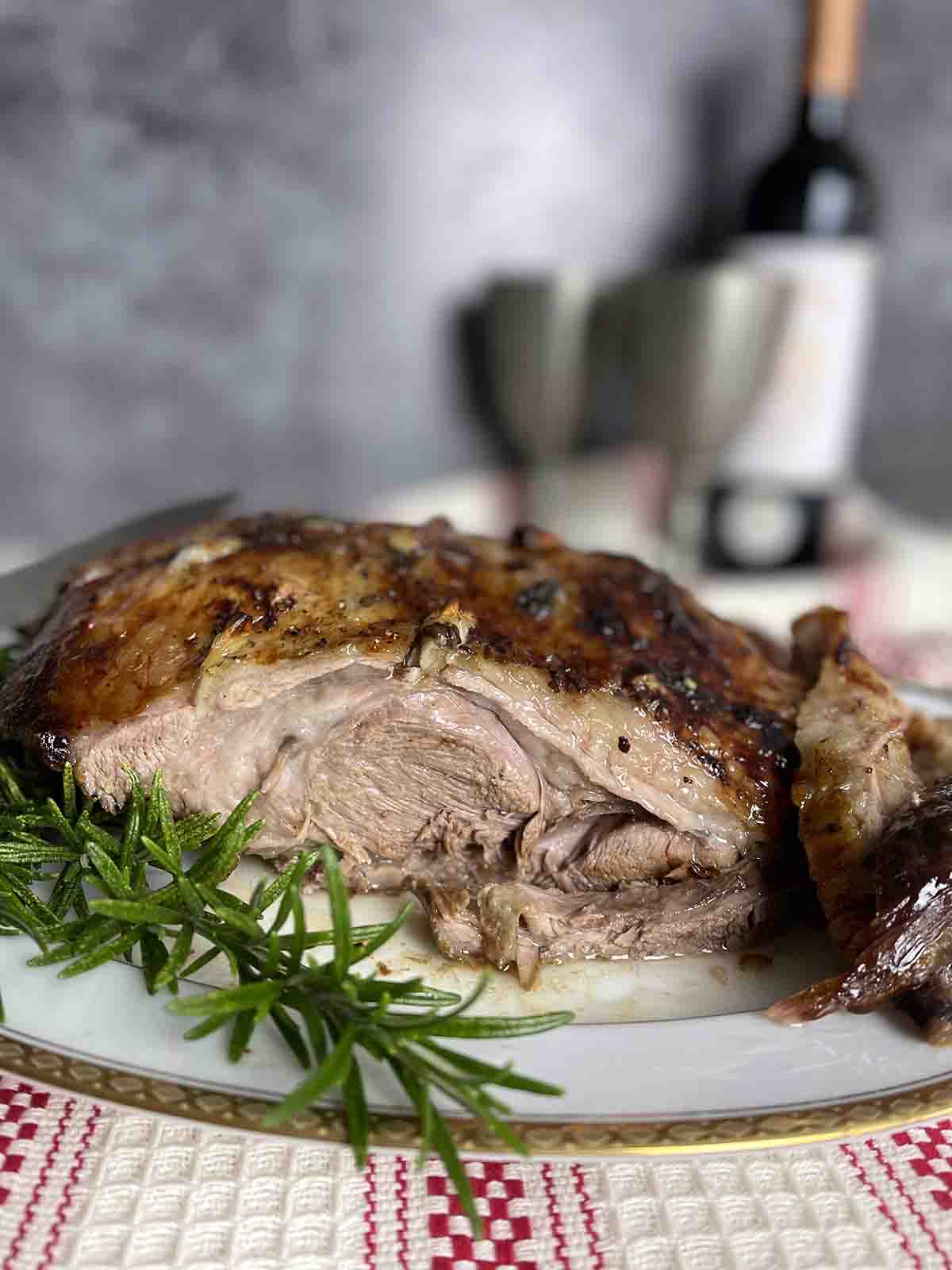 slow cooked lamb shoulder on a plate with rosemary.