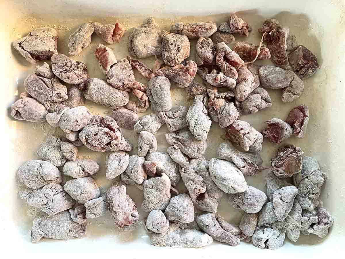 floured meat on a tray.