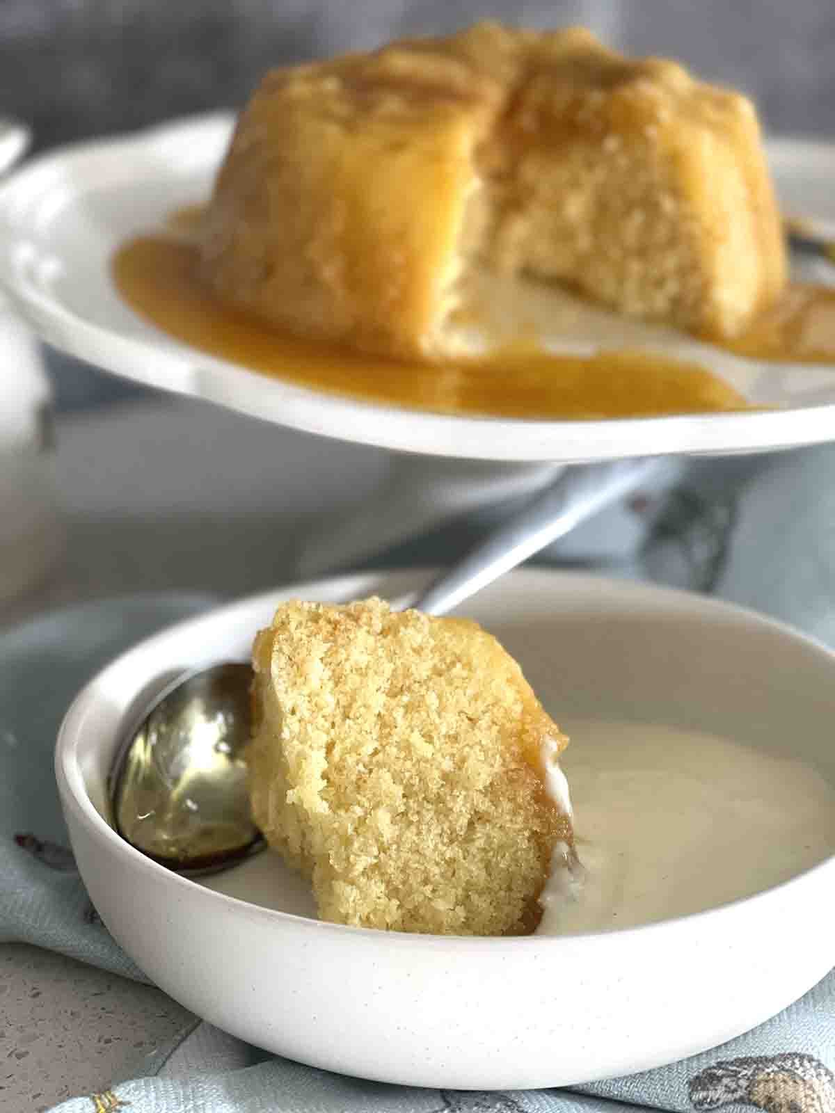 slice of pudding in a bowl with custard.