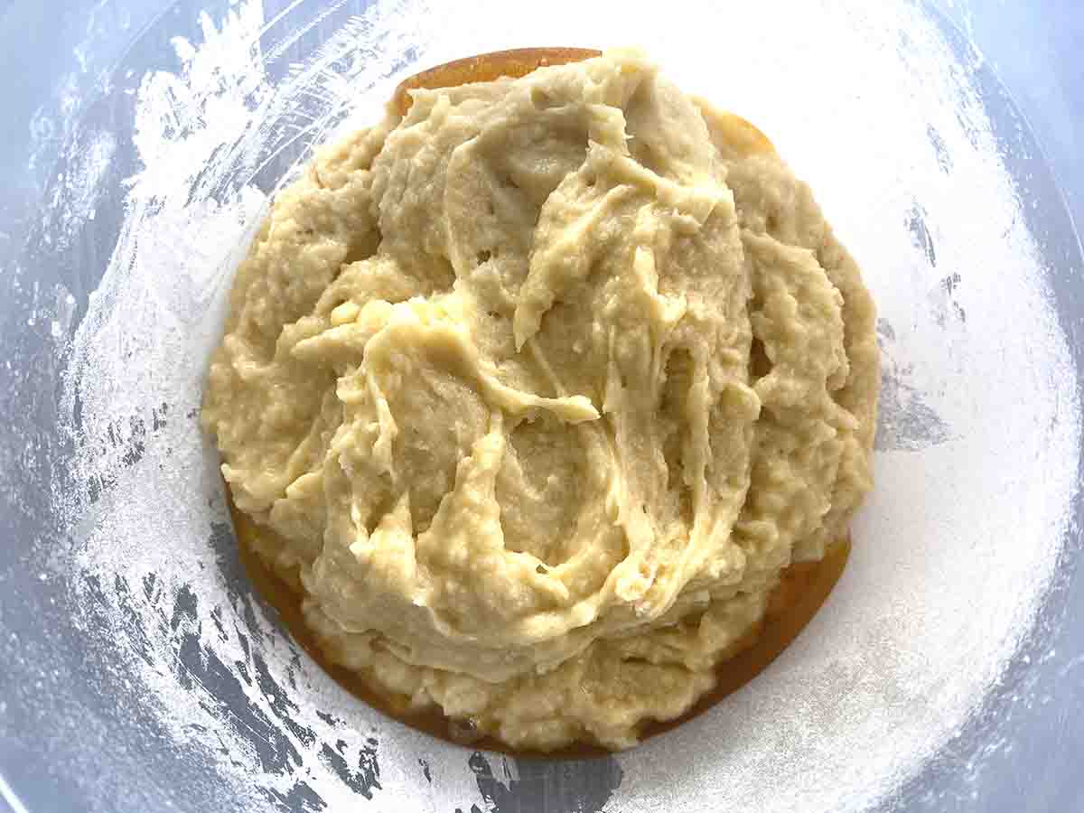 cake mixture added to syrup in a plastic bowl.
