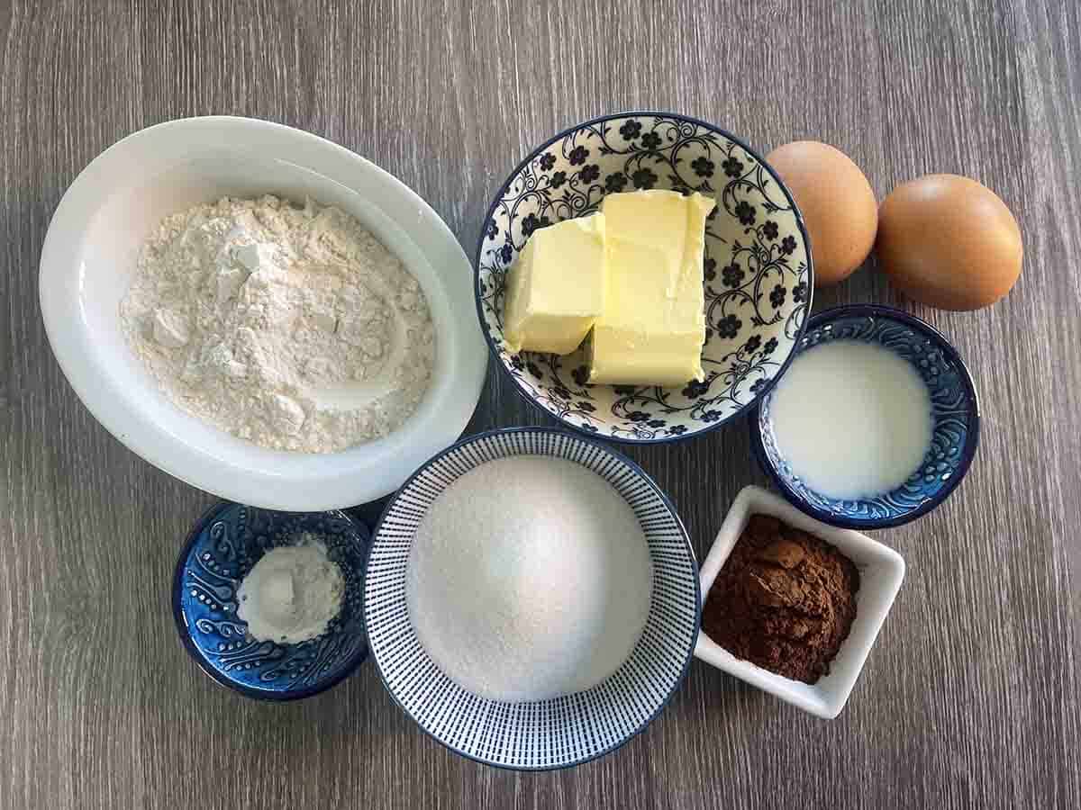 ingredients in bowls including butter, eggs, cocoa,sugar, flour, creme fraiche abd baking powder.