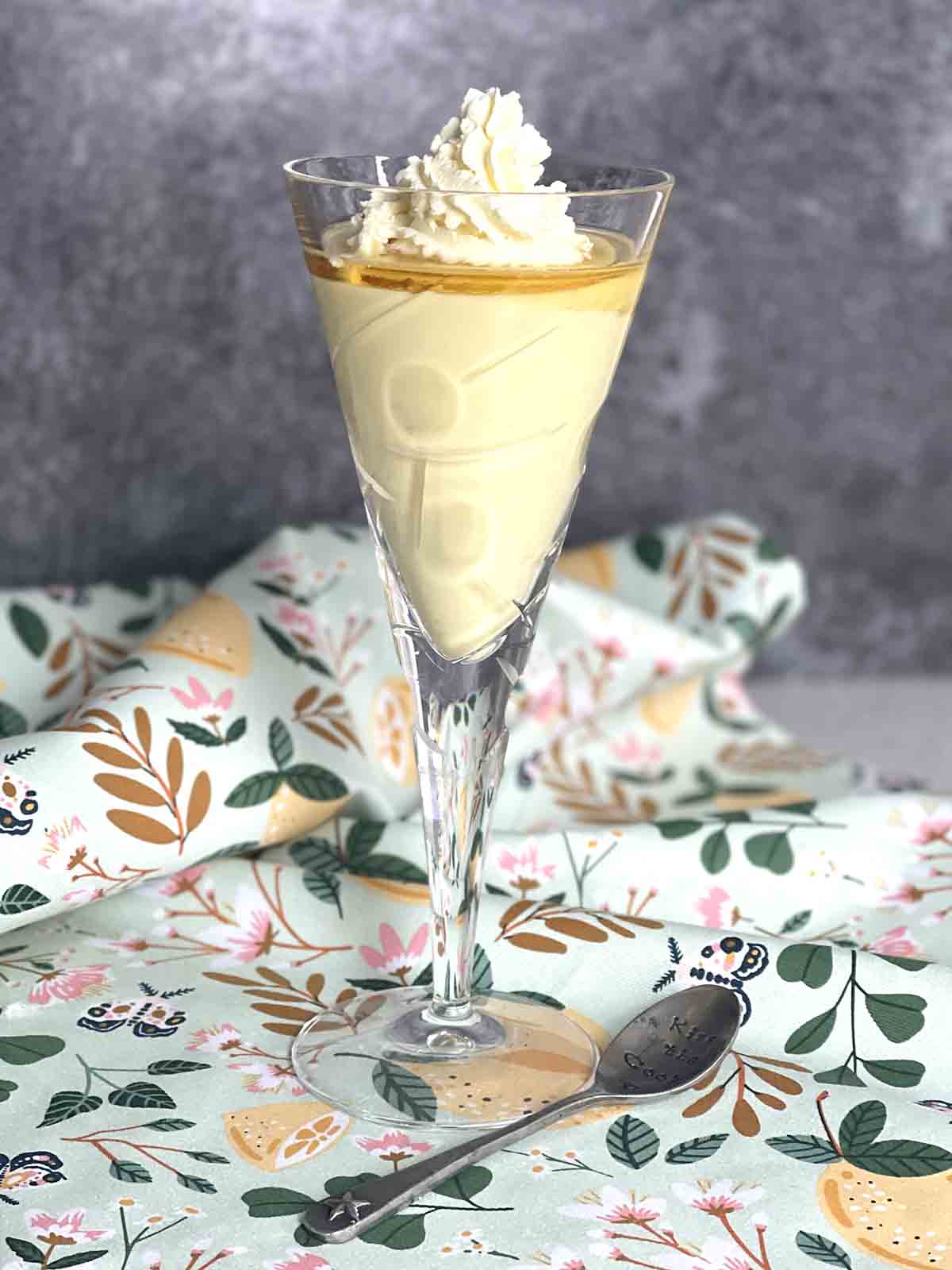 flummery dessert in a glass with cream on top.