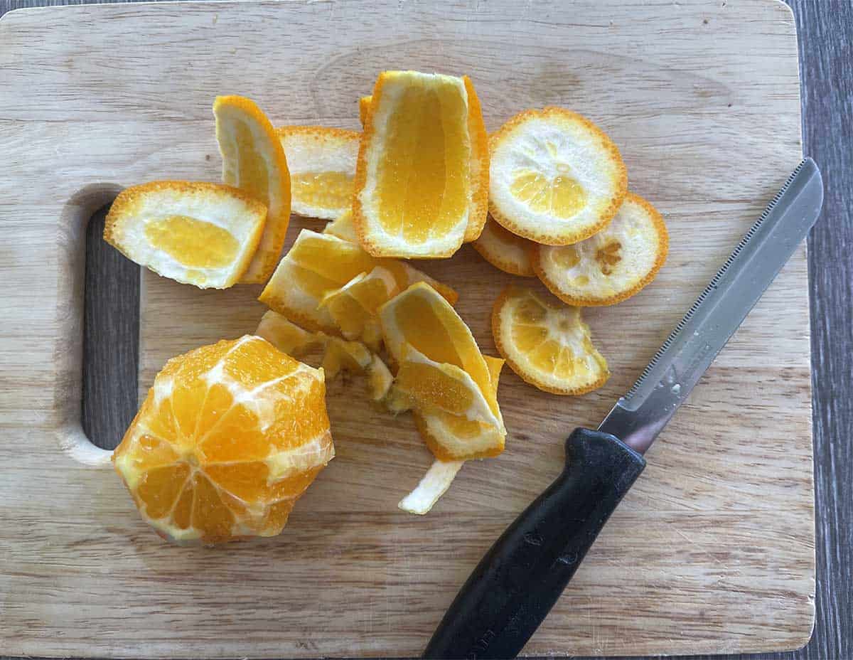 orange with the skin cut off on a board.
