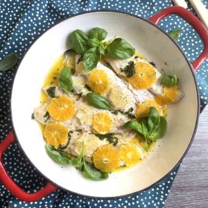 pan fried seabas with orange in a round pan.