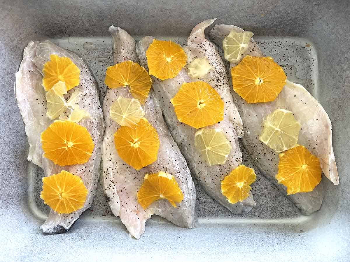 fish topped with orange slices.