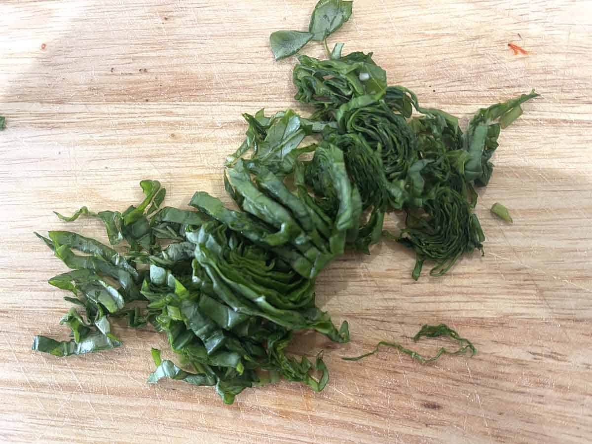 chiffonade of basil on a board.