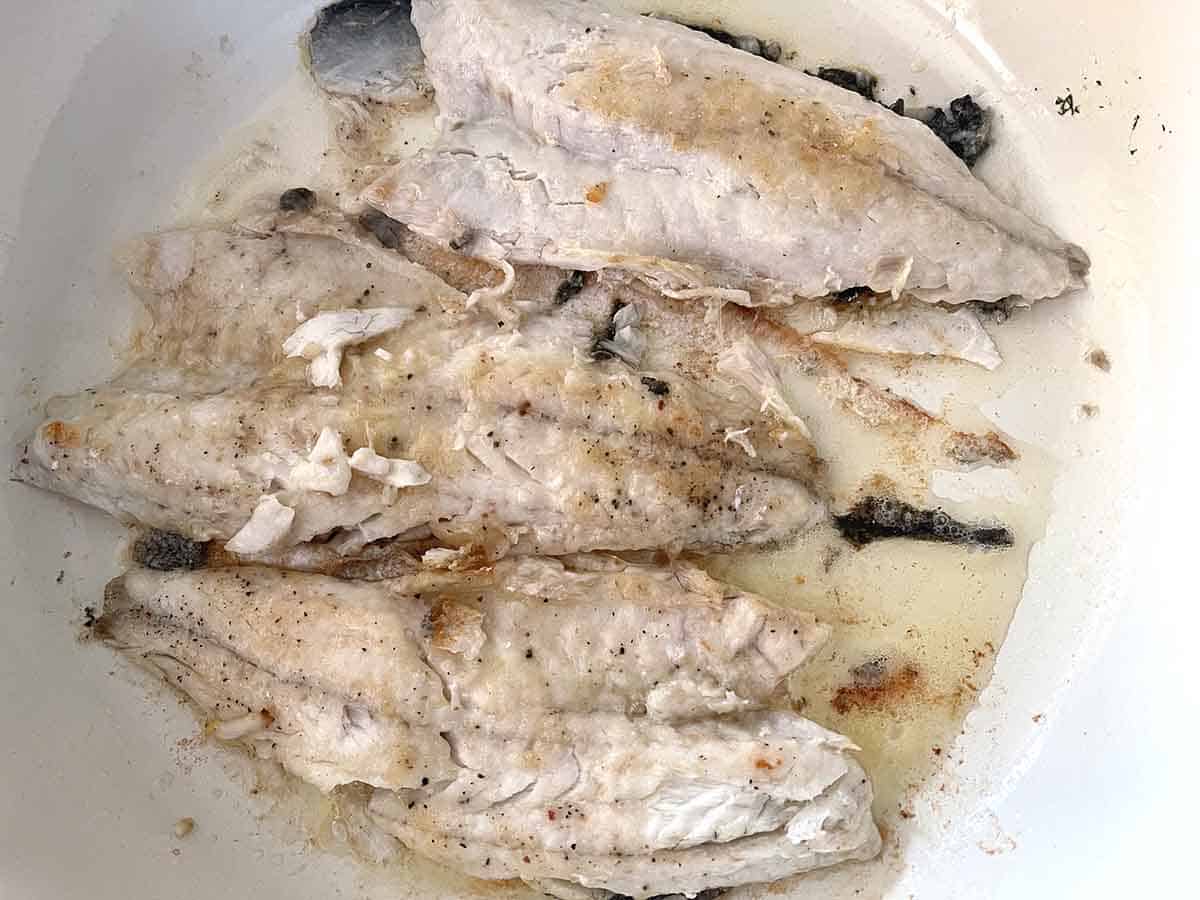 fish frying in a pan.