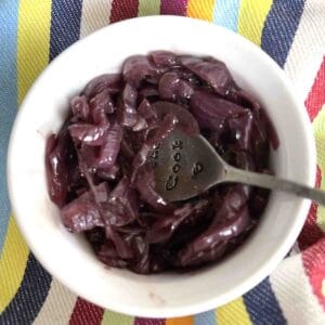 caramelised red onion chutney in a small pot with a spoon.
