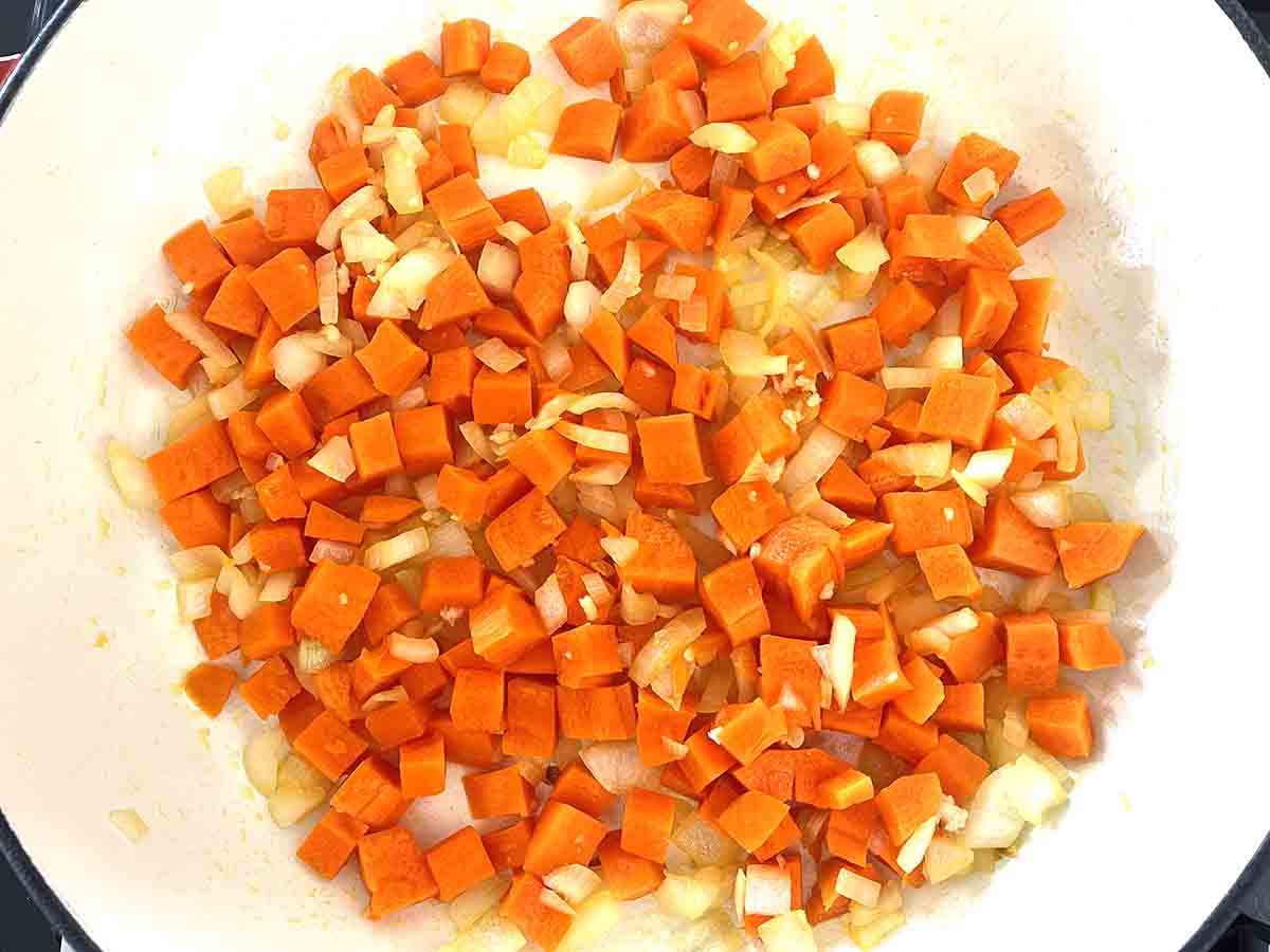 carrots and onions frying in a pan.