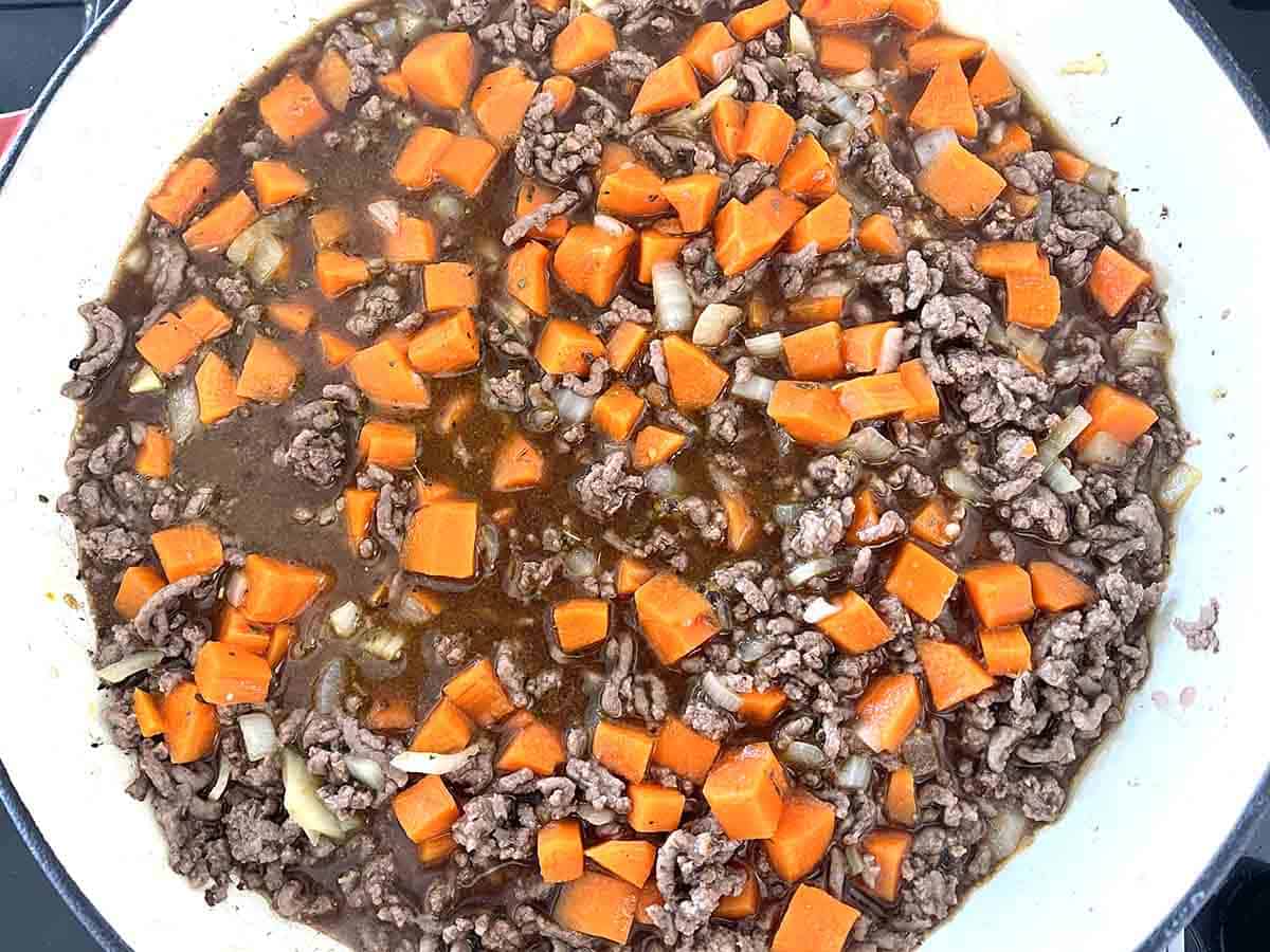 stock and carrots added to pan.