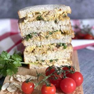 coronation chicken sandwich stacked on a board.