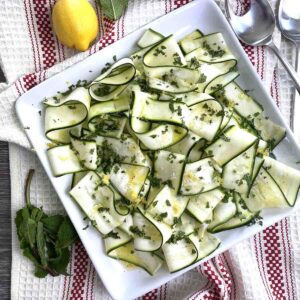 raw courgette salad on a square plate.