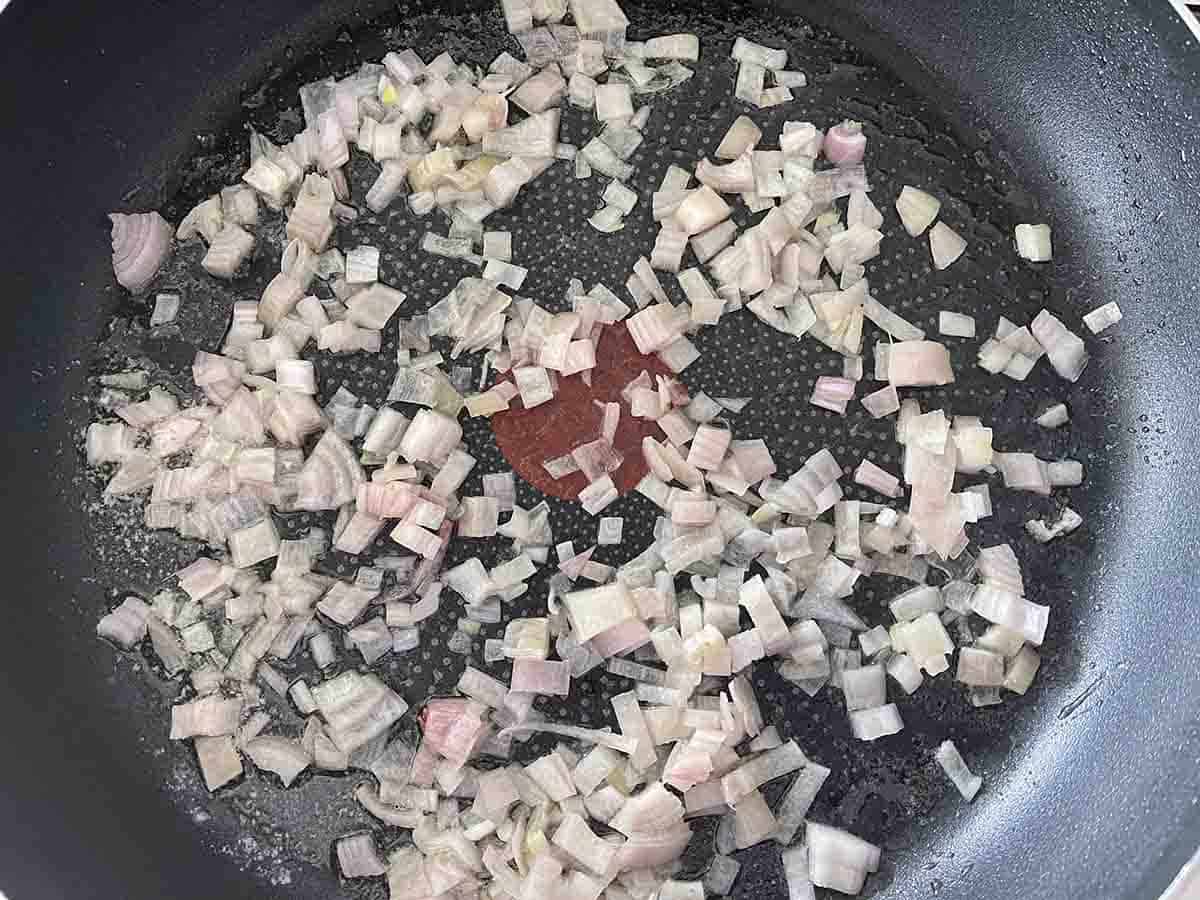 chopped shallots cooking in a pan.