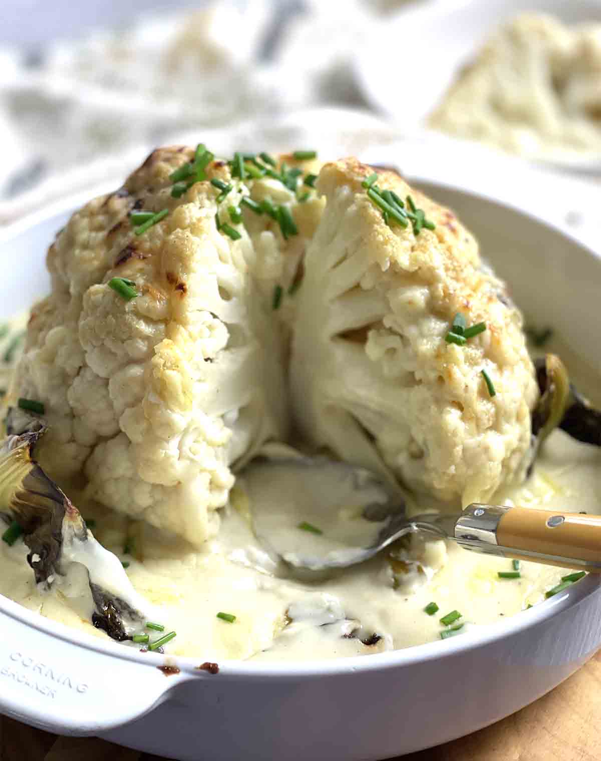 whole roasted cauliflower with portion cut.