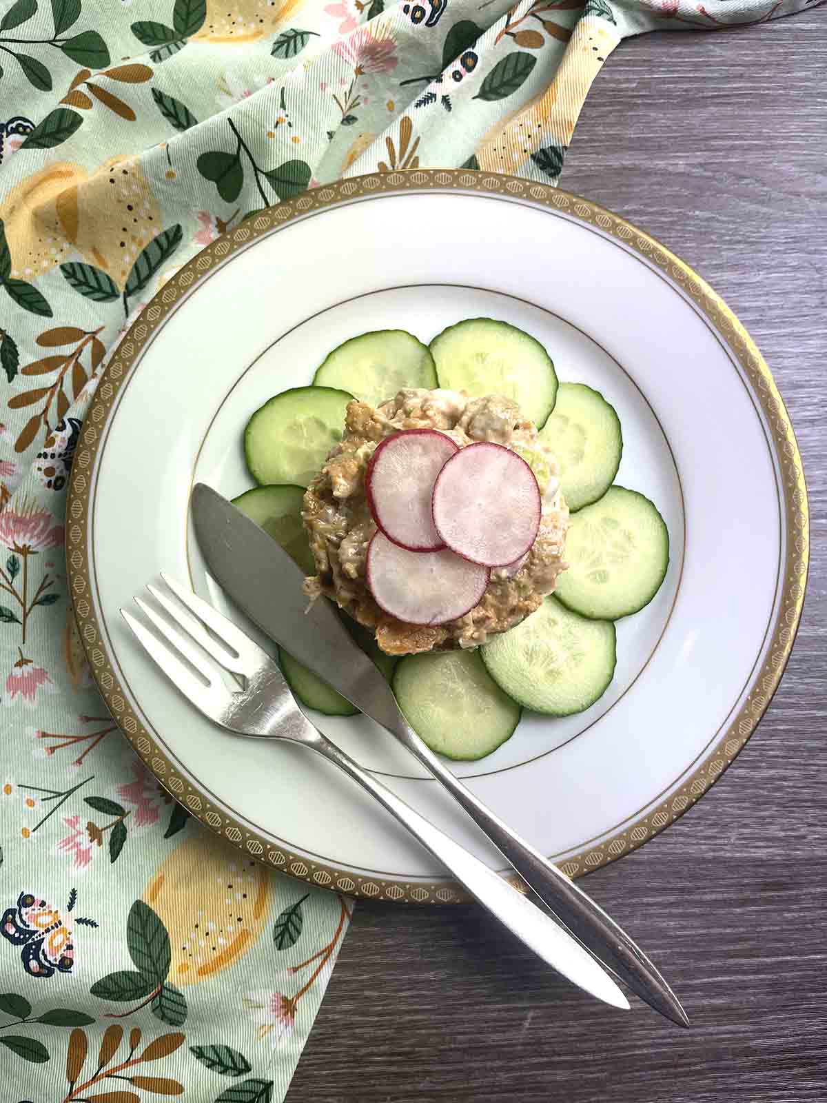 salad on a plate with a knife and fork.