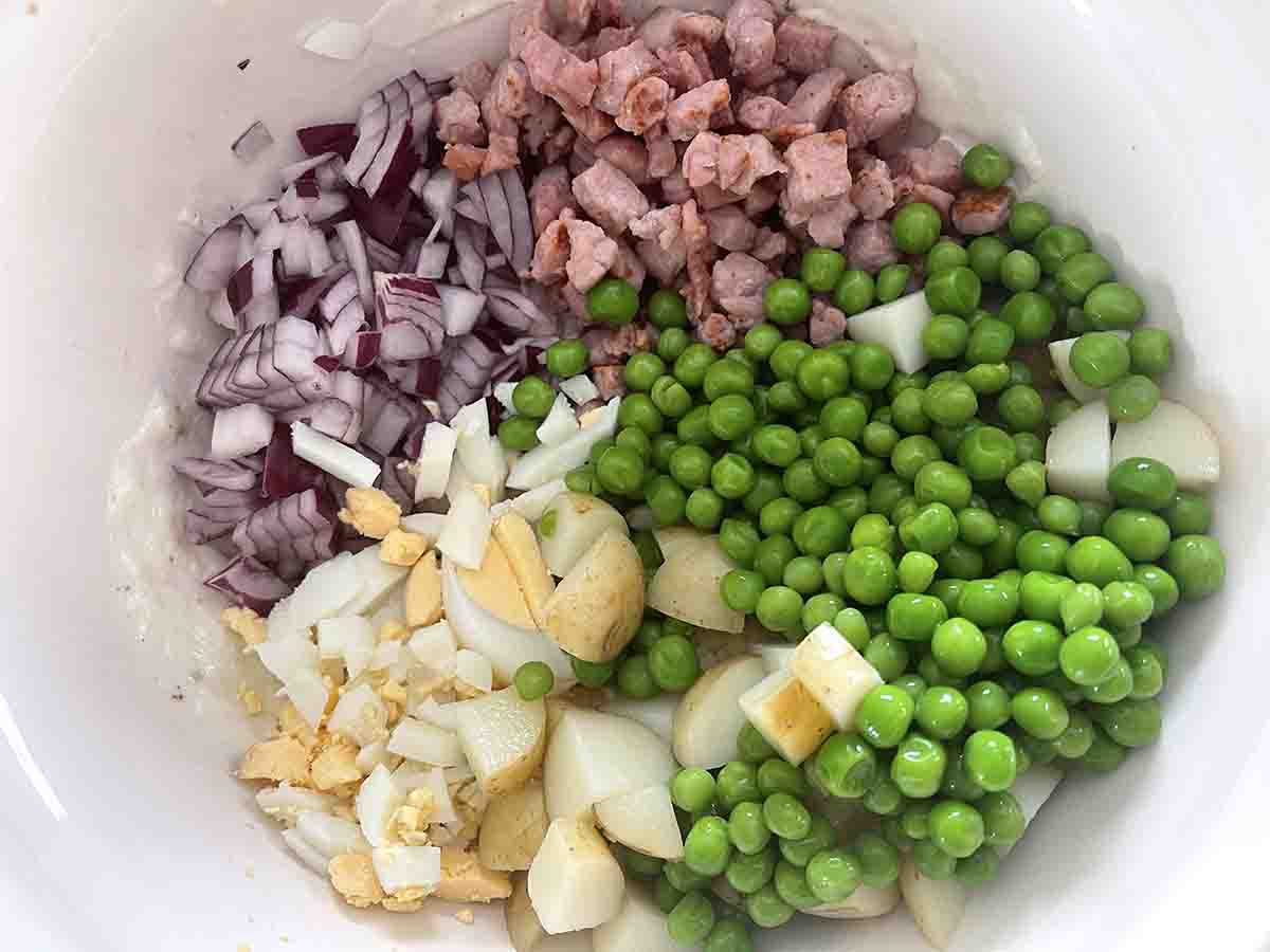 salad ingredients added to a bowl.