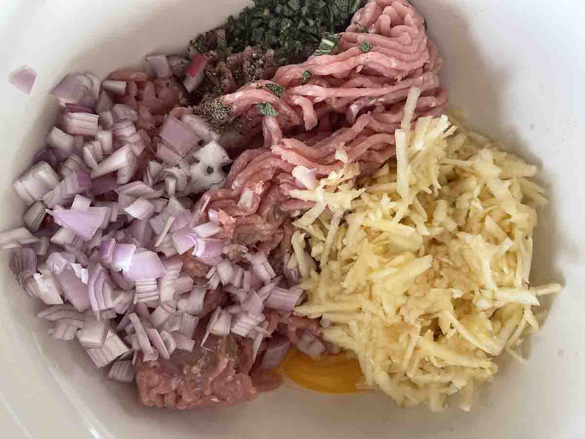 pork, apple and seasoning in a bowl.