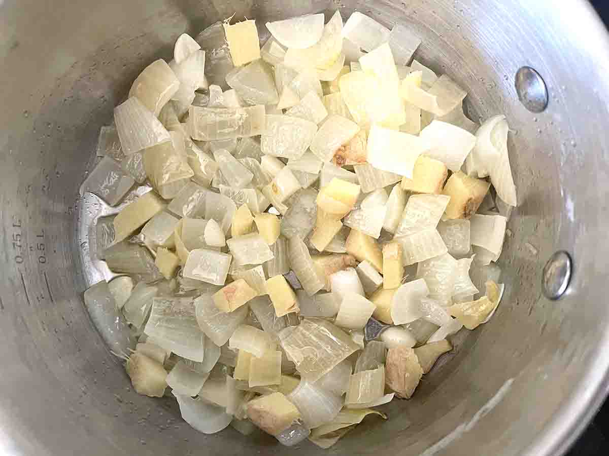 onions garlic and ginger cooking in a saucepan.