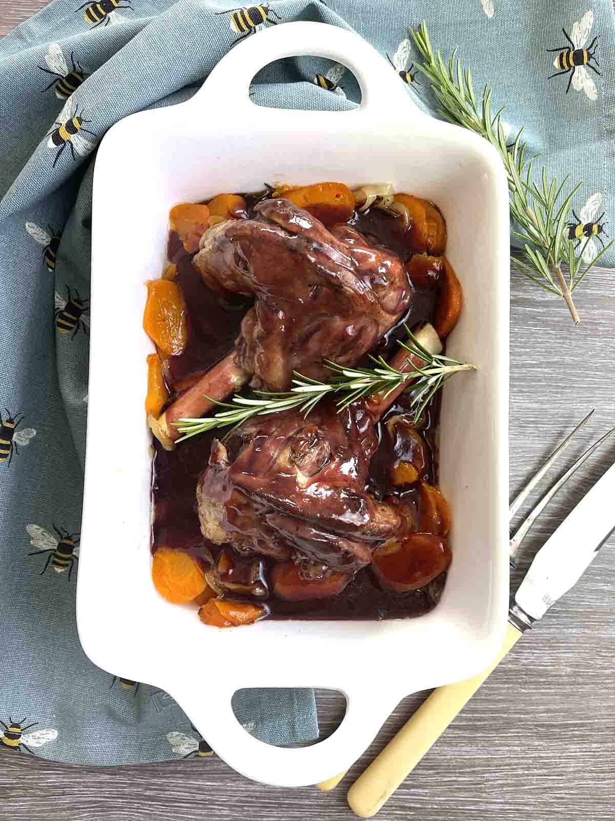 roast lamb shanks in foil on a serving dish.