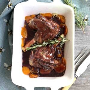roast lamb shanks in foil on a serving dish.