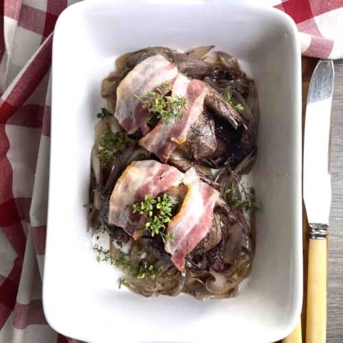 two roast pigeon in a dish.