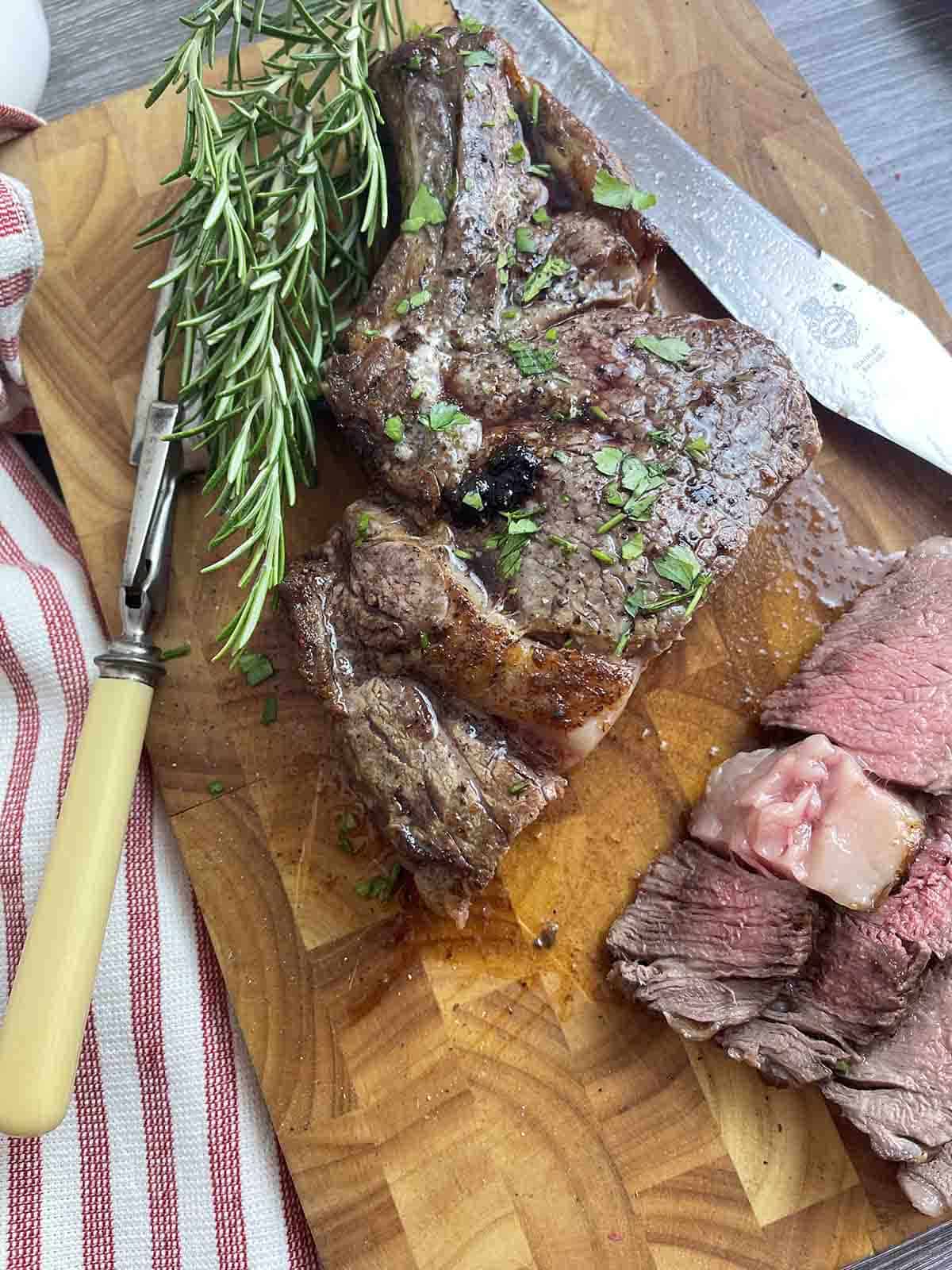 cooked steak cut on a board.