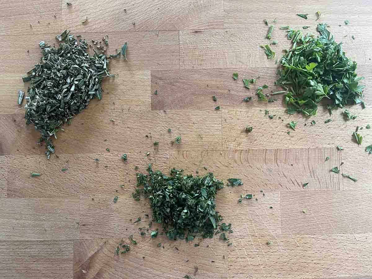 chopped herbs on a board.